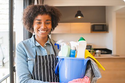 afro woman holding bucket with cleaning items